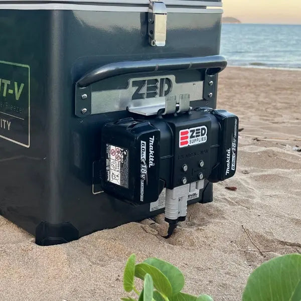 A ZED Middle Man adapter running two Makita 18V batteries to power a 12V Engel fridge on a beach
